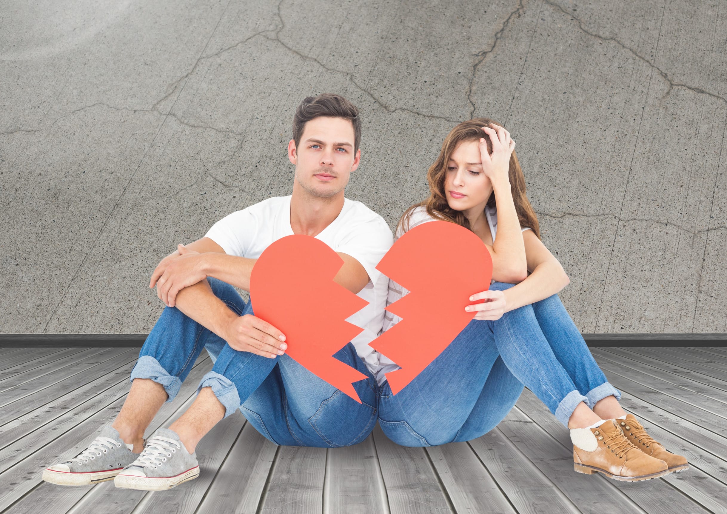 Upset couple holding broken heart against digitally generated wall background