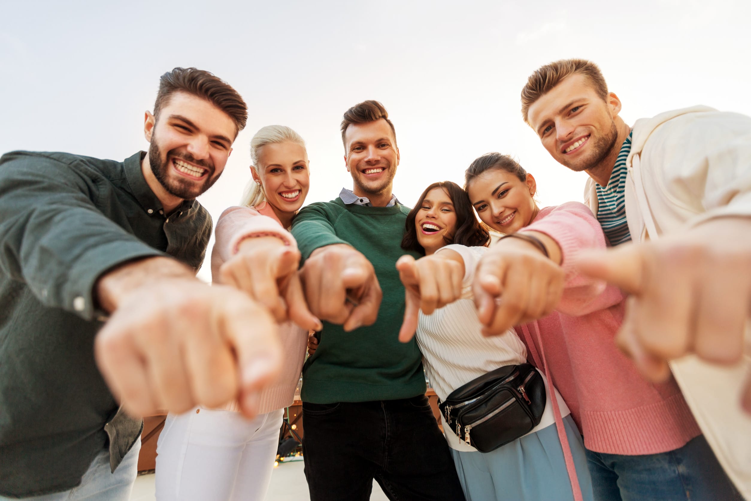people, gesture and friendship concept - happy friends pointing finger at you