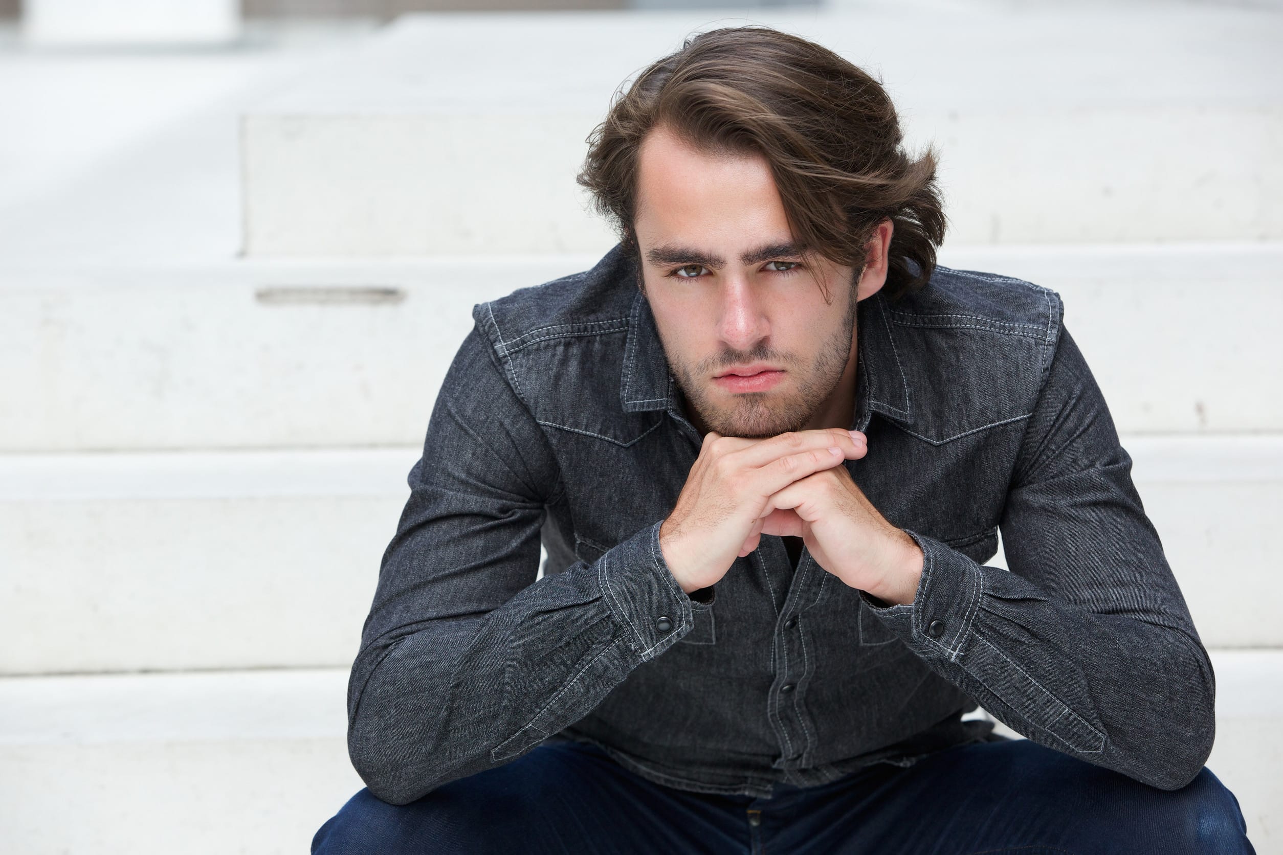 Close up portrait of a handsome young man sitting outside