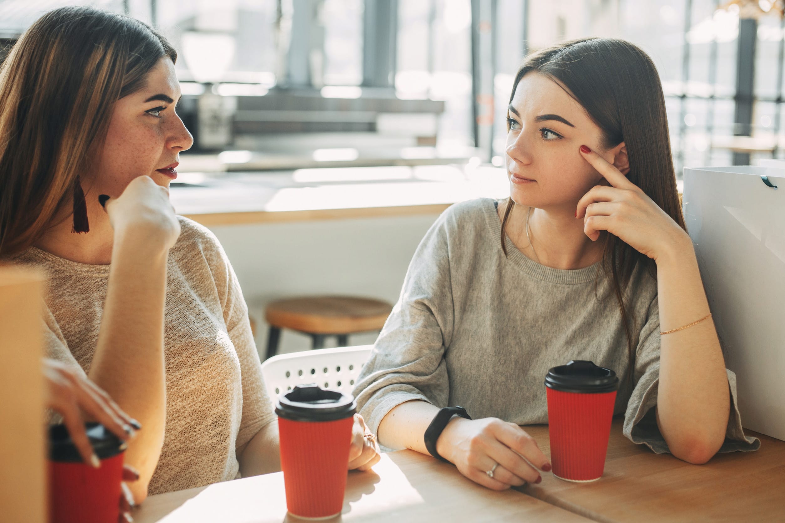 Best friends have good time, drinking coffee and friendly talk while sitting at cafe after shopping. People, leisure, communication, eating and drinking 