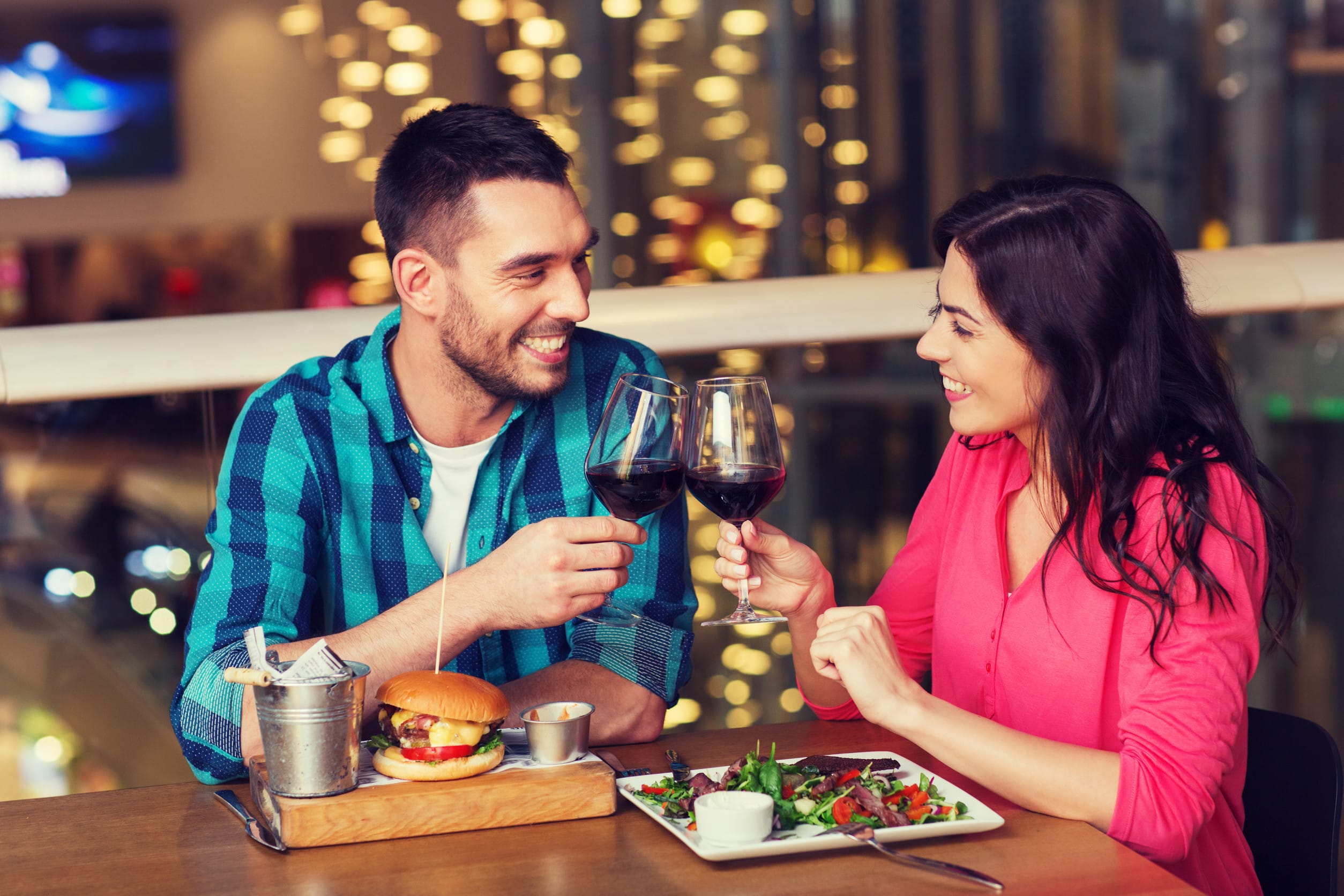 leisure, celebration, food and drinks, people and holidays concept - smiling couple having dinner and drinking red wine at date in restaurant