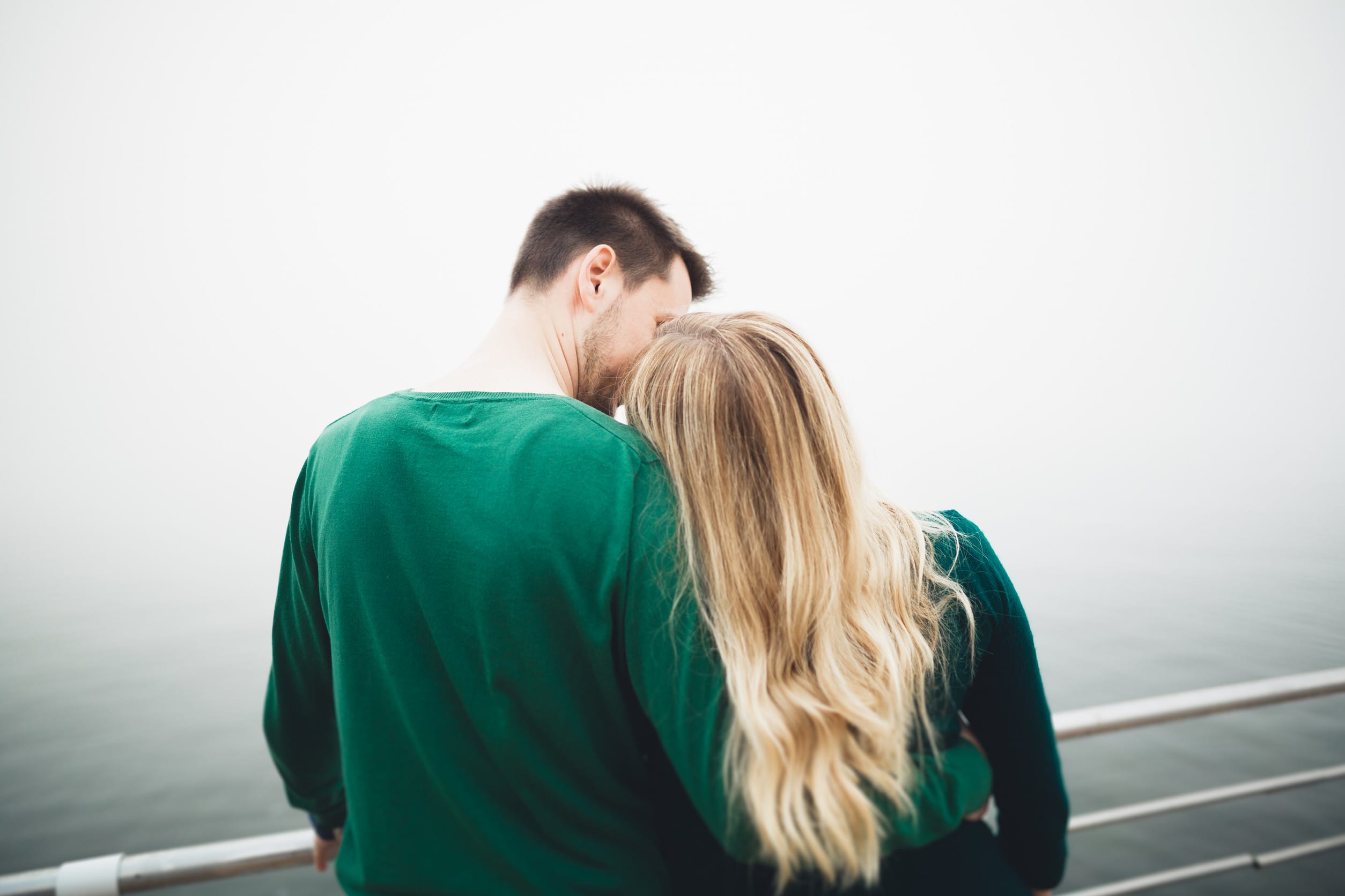 Lovely couple kissing and hugging on a sea dock.