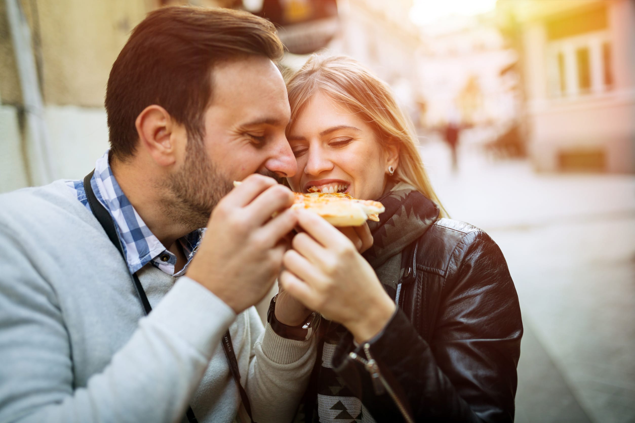 Tourist happy couple sharing pizza