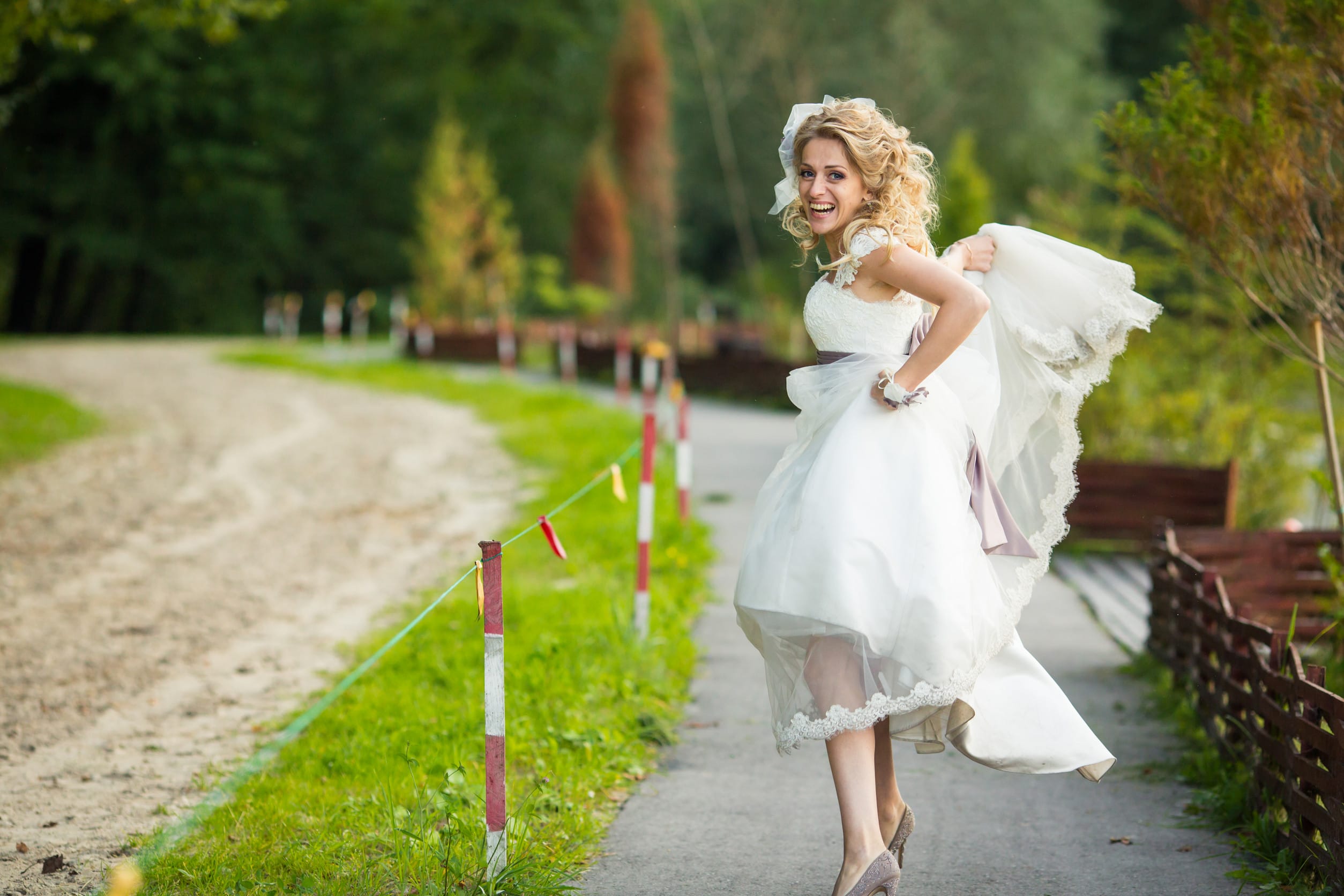 Stylish bride looks funny running along the path