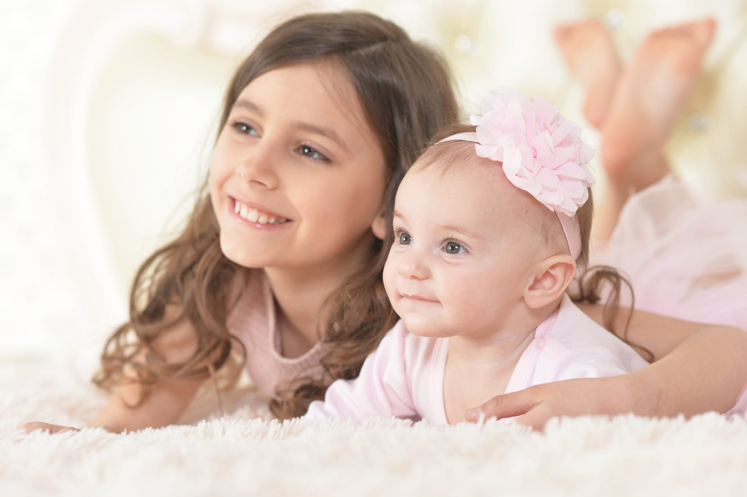 two beautiful cute sisters posing in bed at home