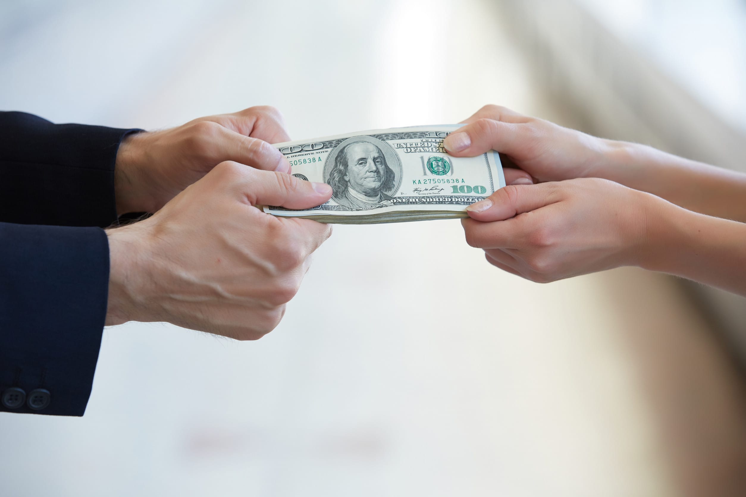 business woman and a businessman hold money