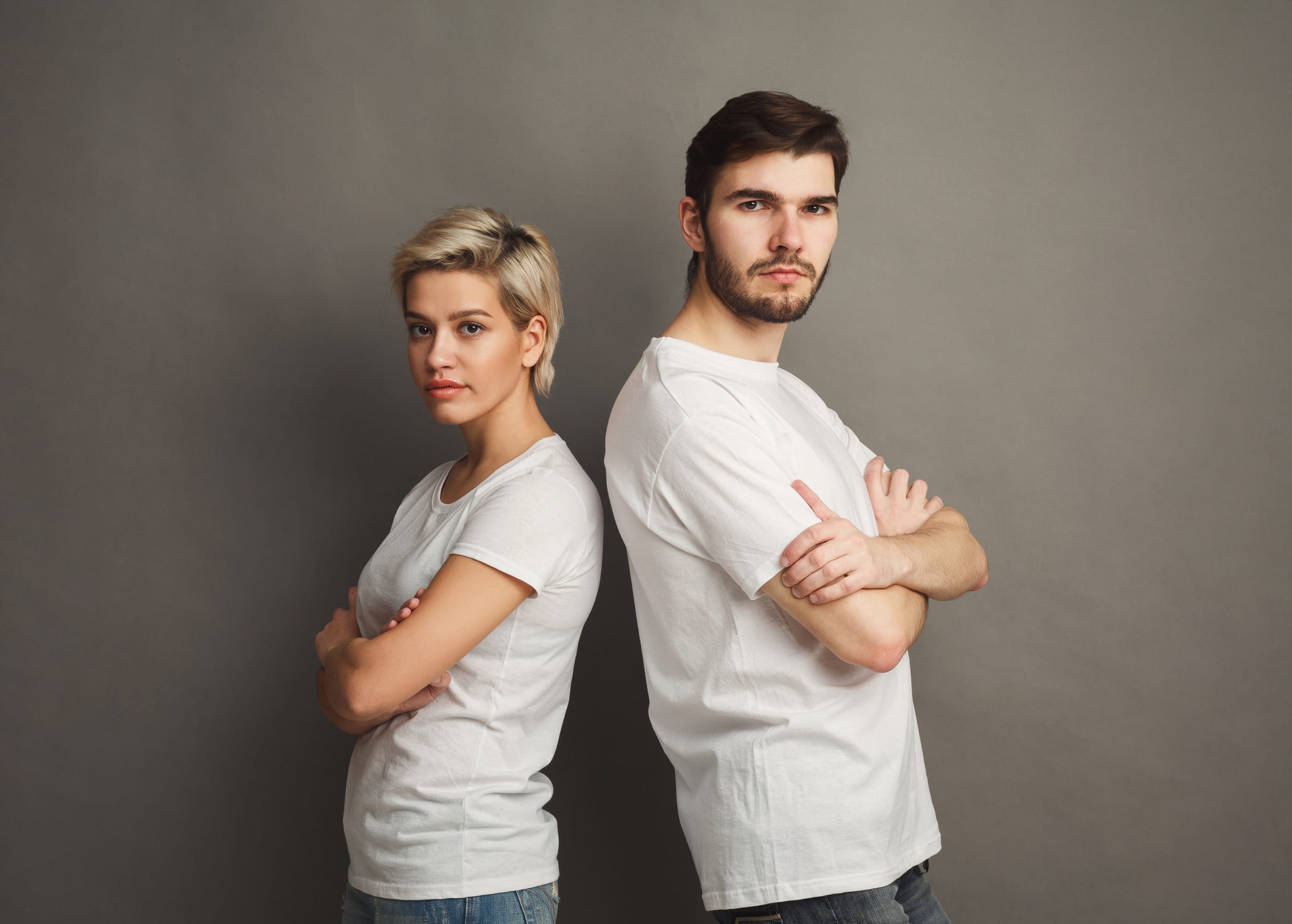 Serious woman stand back to boyfriend. Couple after arguing, copy space