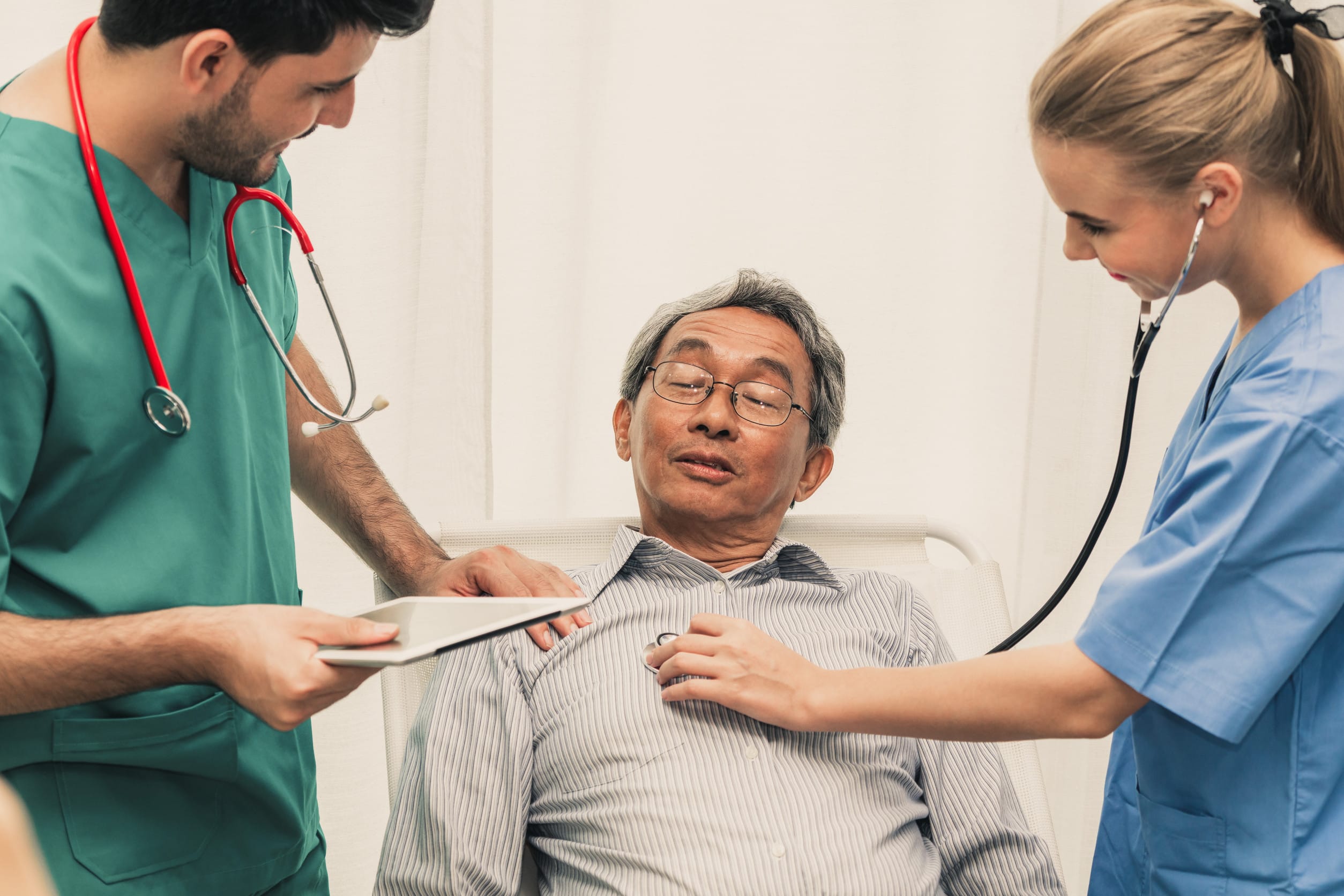 Doctor team taking care of senior adult man patient lying on bed in hospital ward. Medical healthcare staff service treatment concept.