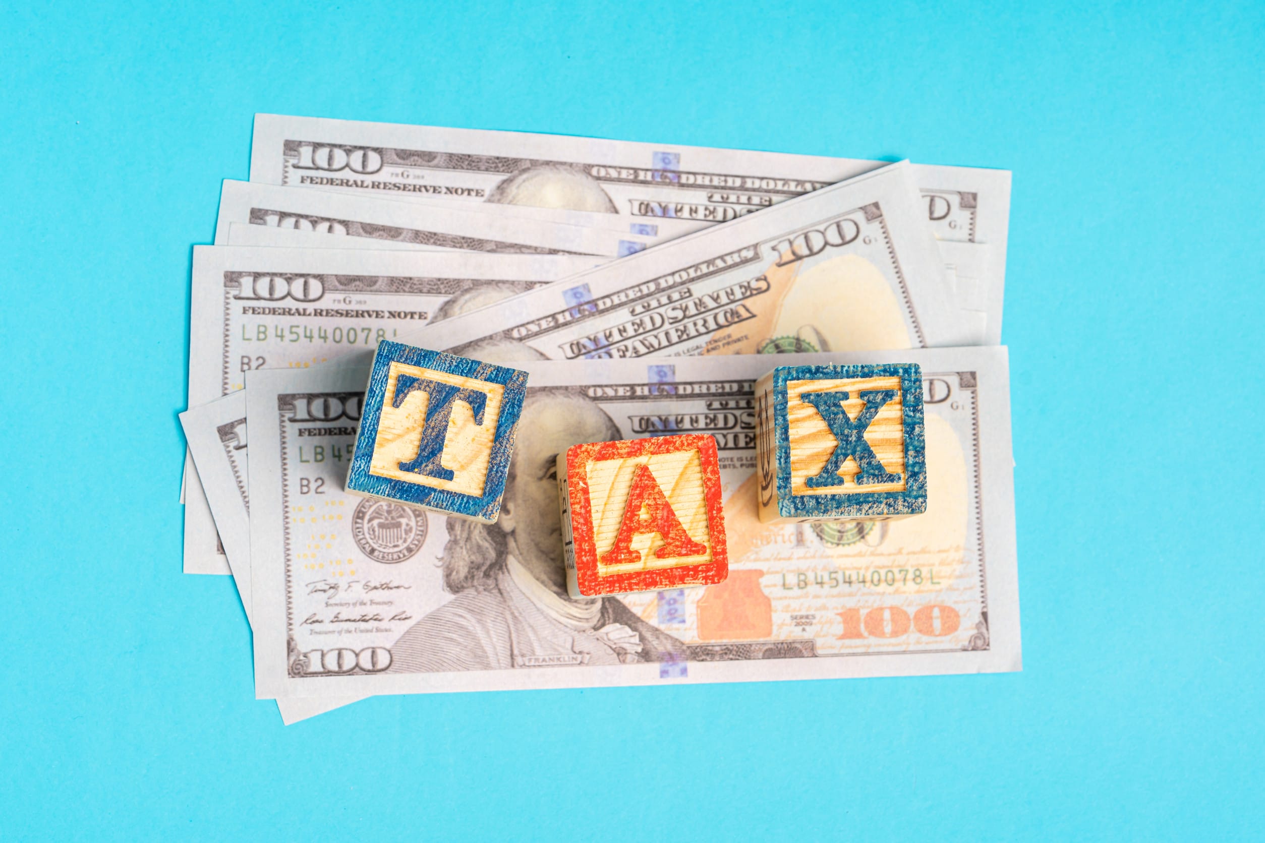 TAX wordings on woodens blocks with US Dollar bills