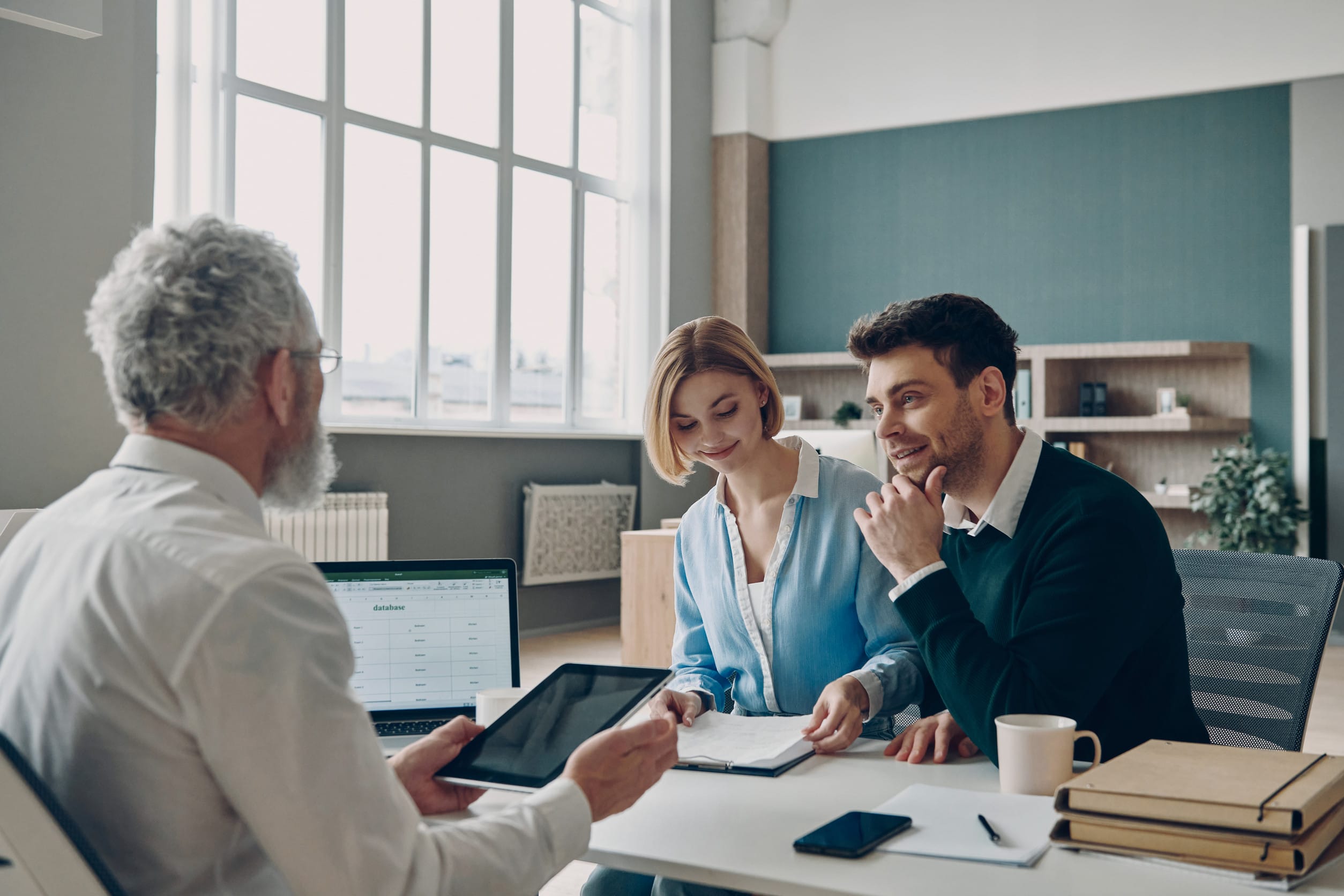 Financial advisor using digital tablet while explaining options to his clients in the office