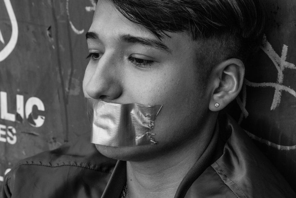 man with tape over his mouth