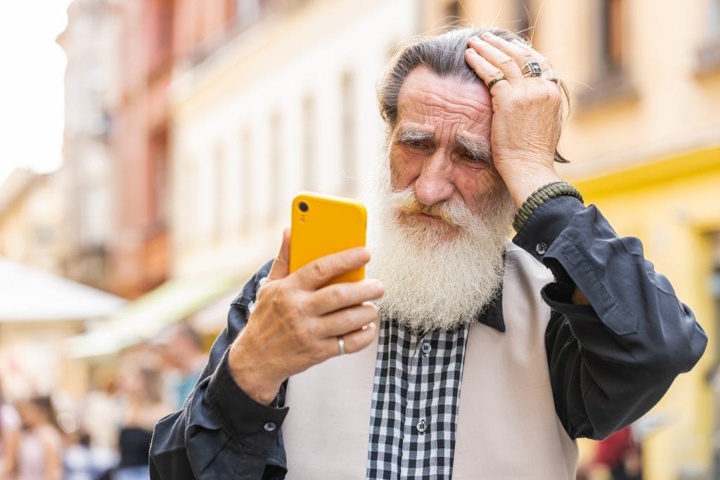 Surprised elderly old man use smartphone loses, bad news, fortune loss, fail outdoors in city street